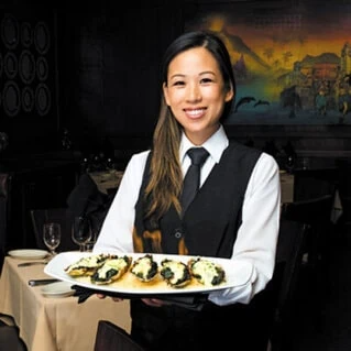 an employee serving food at Ruth's Chris Steak House