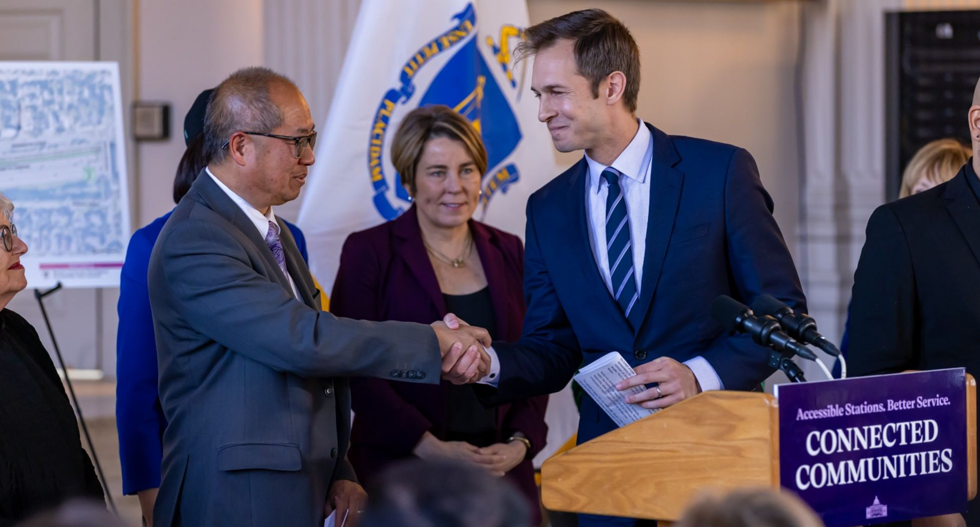 a man shaking another mans hand at a table