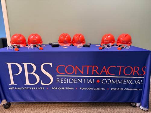 A table with a blue table with red helmets on it

Description automatically generated