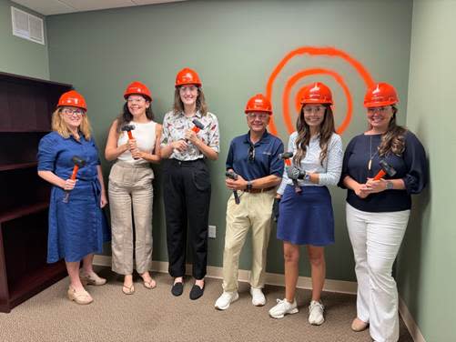 A group of people wearing hard hats holding hammers

Description automatically generated