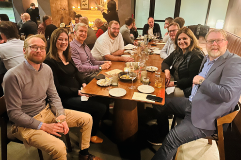 A group of people sitting around a table 
Description automatically generated, Picture