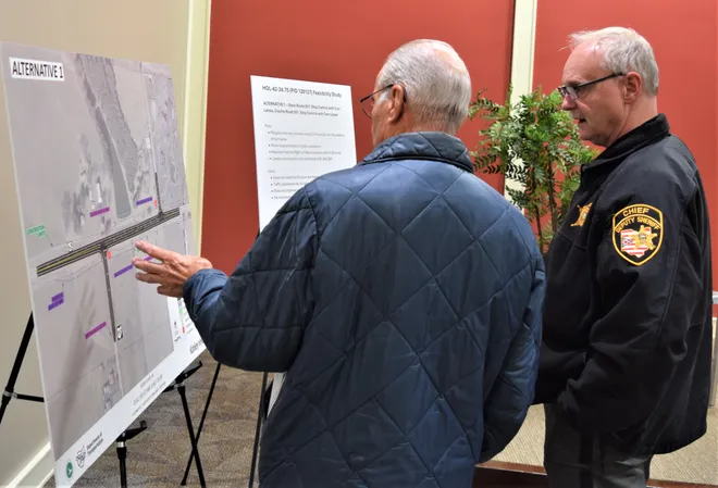 Holmes County Chief of Deputies Richard Haun, right, listens as a resident talks about the U.S. Route 62/state Route 39, state Route 557 and County Road 201 intersections safety improvement project information at a meeting in Charm. The least costly option involves turn lates only.