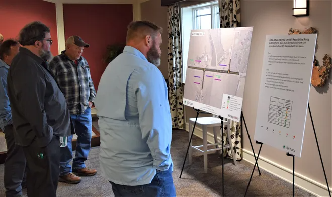 Holmes County Engineer Chris Young looks over one of the alternatives for the U.S. Route 62/state Route 39, state Route 557 and County Road 201 intersections safety improvement project plans at the meeting in Charm. One option presented involved turn lanes and a traffic signal.