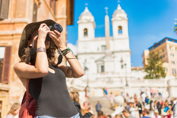 Female tourist taking photograph in foreign city