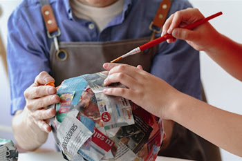 Two people working on a paper mâché project