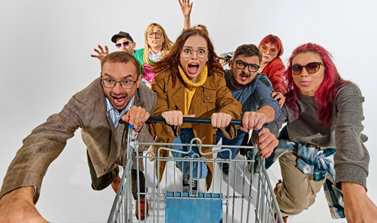 Group of shoppers racing forward with a cart