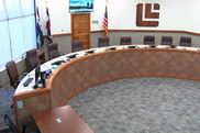 Photo of empty dais in Louisville City Council Chamber