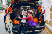 Kids in the trunk of a car decorated for Halloween