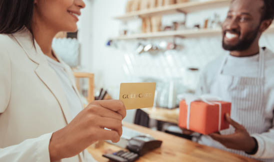 Woman making in-store gift card purchase