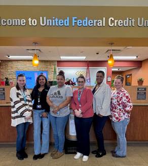 A group of people standing in front of a bank

AI-generated content may be incorrect.