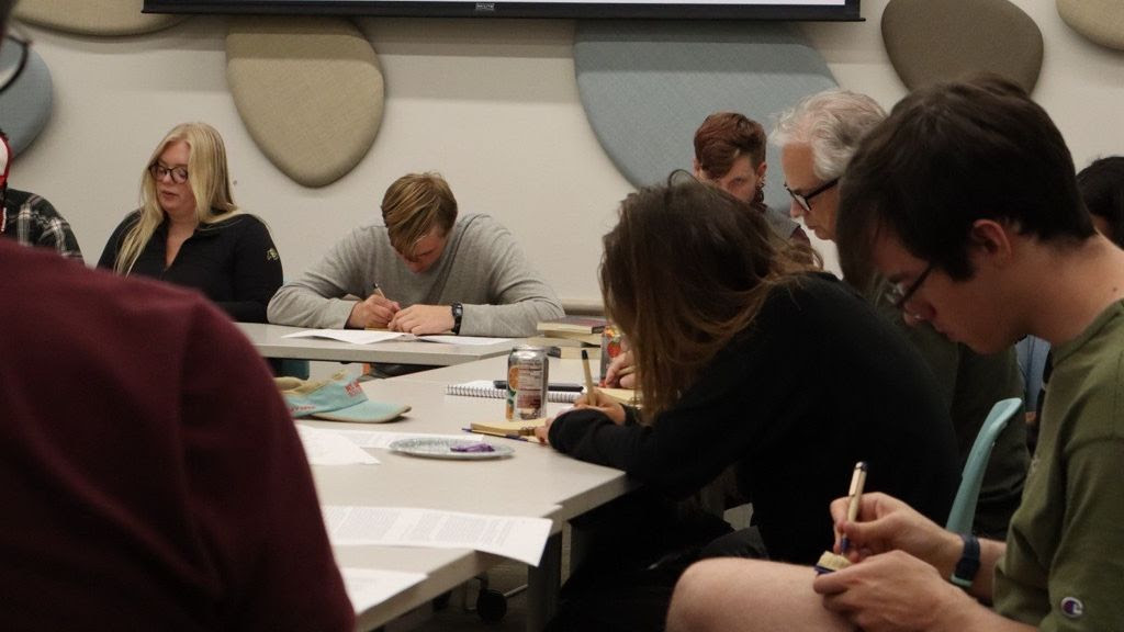 People sitting around table writing