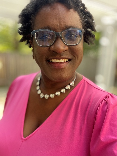 A person wearing a pink shirt and glasses 
AI-generated content may be incorrect.