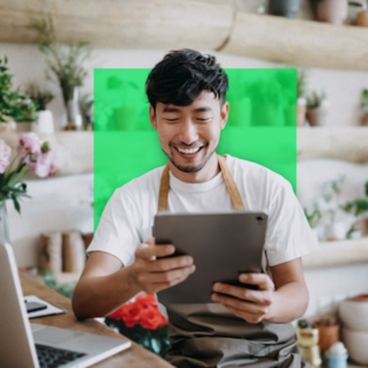 a man smiling while holding a tablet