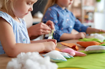 Children sewing small decorative pillows