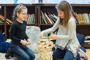 Two girls building with KEVA planks