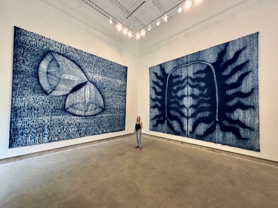 A person standing in a room with large artwork
AI-generated content may be incorrect.