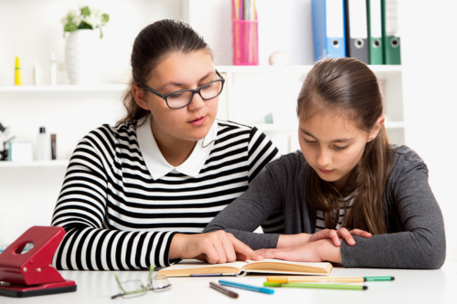 teen and child reading together