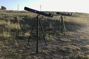 Two telescopes in a grassy area