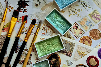Paintbrushes, paints, stickers, and decorative paper