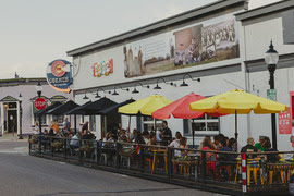Street scene at Verde in downtown Louisville with patrons eating on outdoor patio