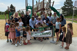 Group of Louisville city officials and children at the grand reopening of Enclave Park in 2025