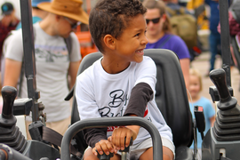 Kid sitting on a truck at the Touch-A-Truck Event 