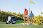 couple golfing with cart