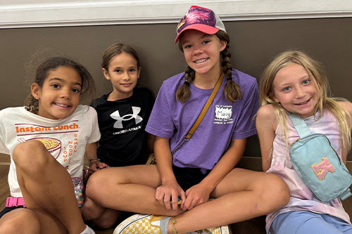 Counser in training with three summer campers 