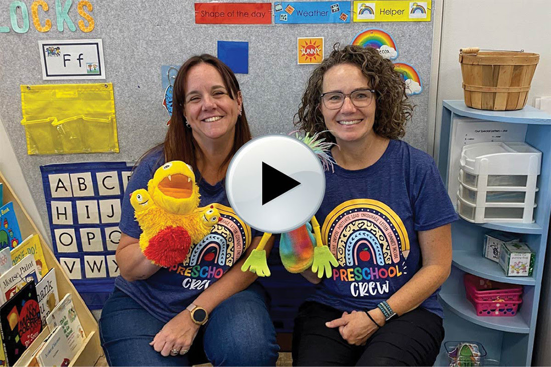 Preschool teachers with play button