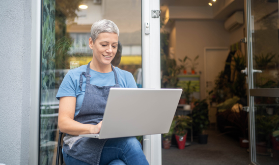 Small business owner working on a laptop in her shop.