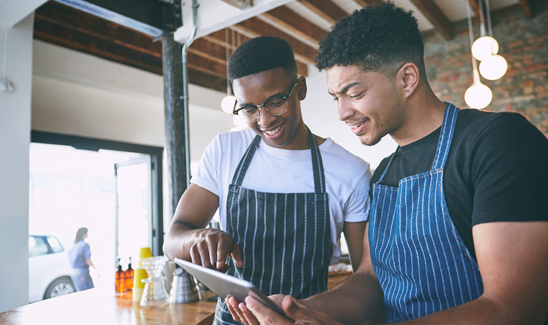 Restaurant employee team members engaging with a tablet.