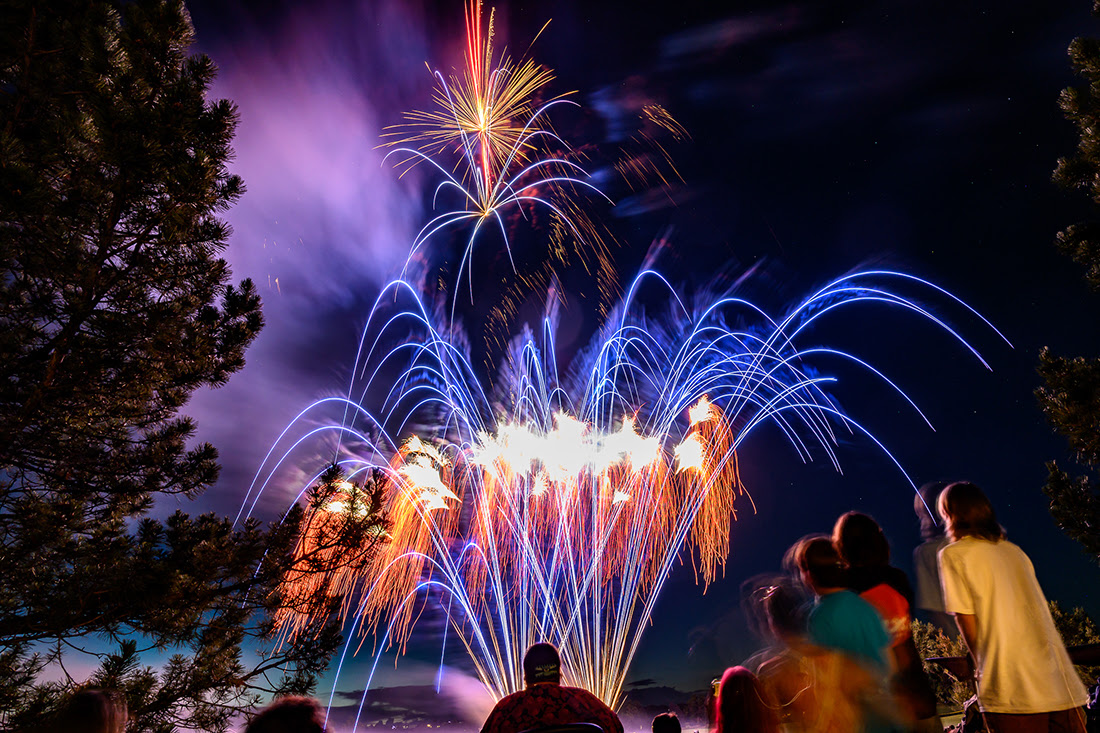 A crowd of people watches fireworks at Louisville