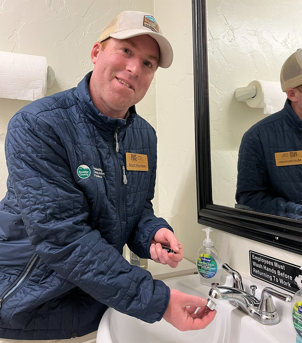 A PACE advisor installs an aerator on a sink.