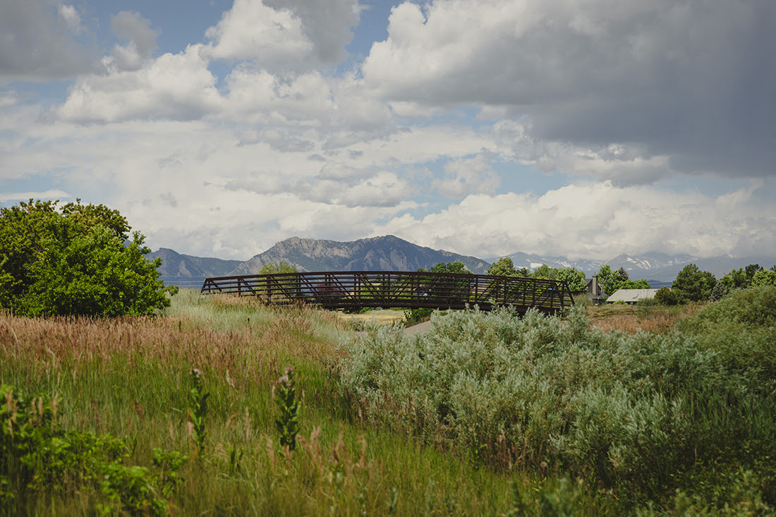 Pedestrian bridge near Harper Lake with Flatirons in the background