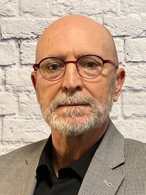 A person with glasses and a beard

Description automatically generated