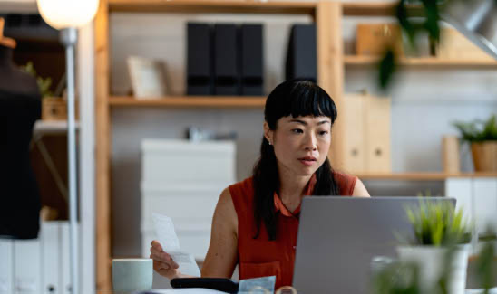 Business woman works on her laptop at her desk.