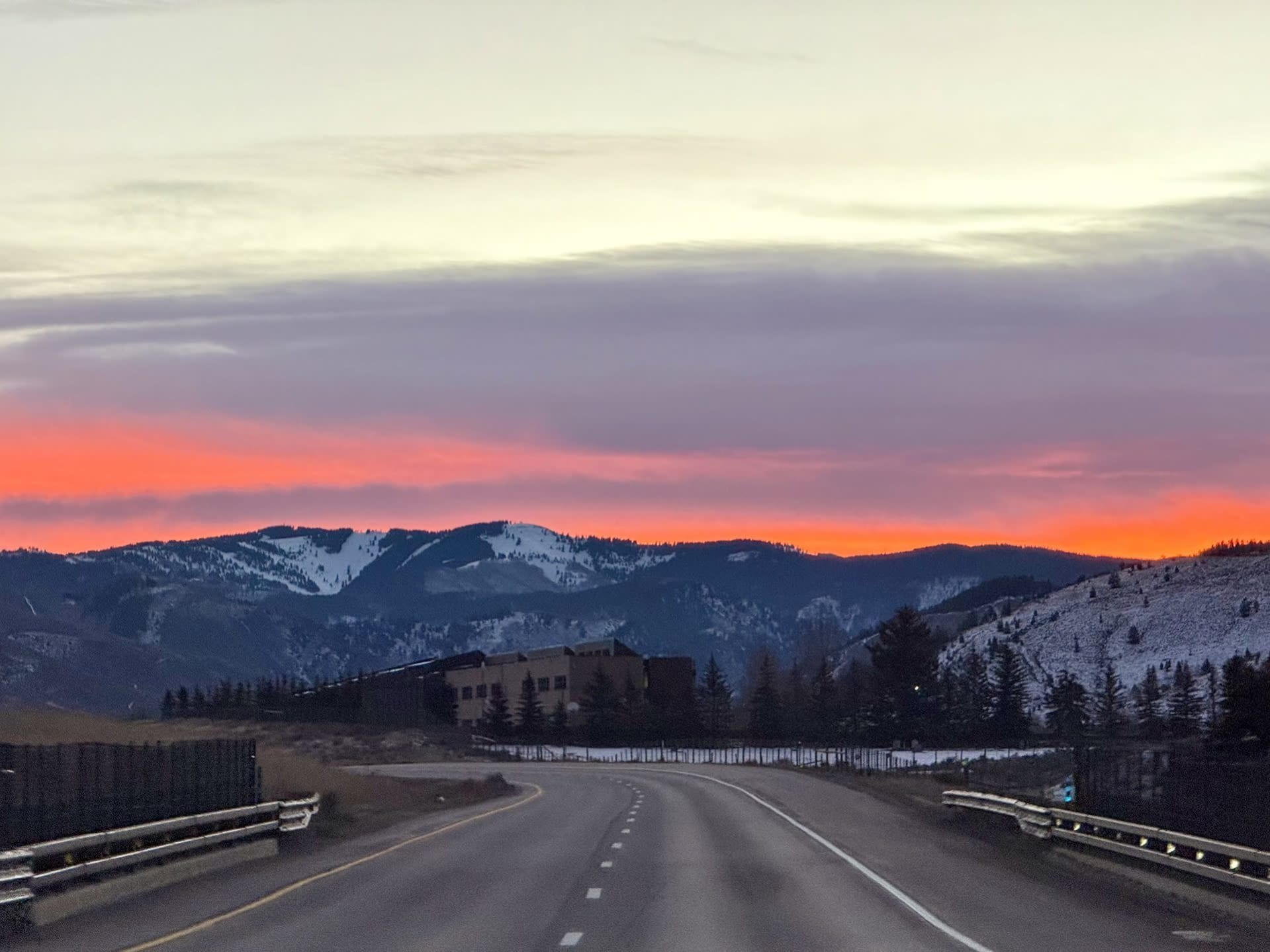 I-70 curving through snowy Colorado hills at dawn