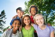 Group of five tweens posing for a photo outdoors