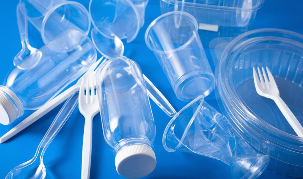 A pile of single use plastics like cups and forks