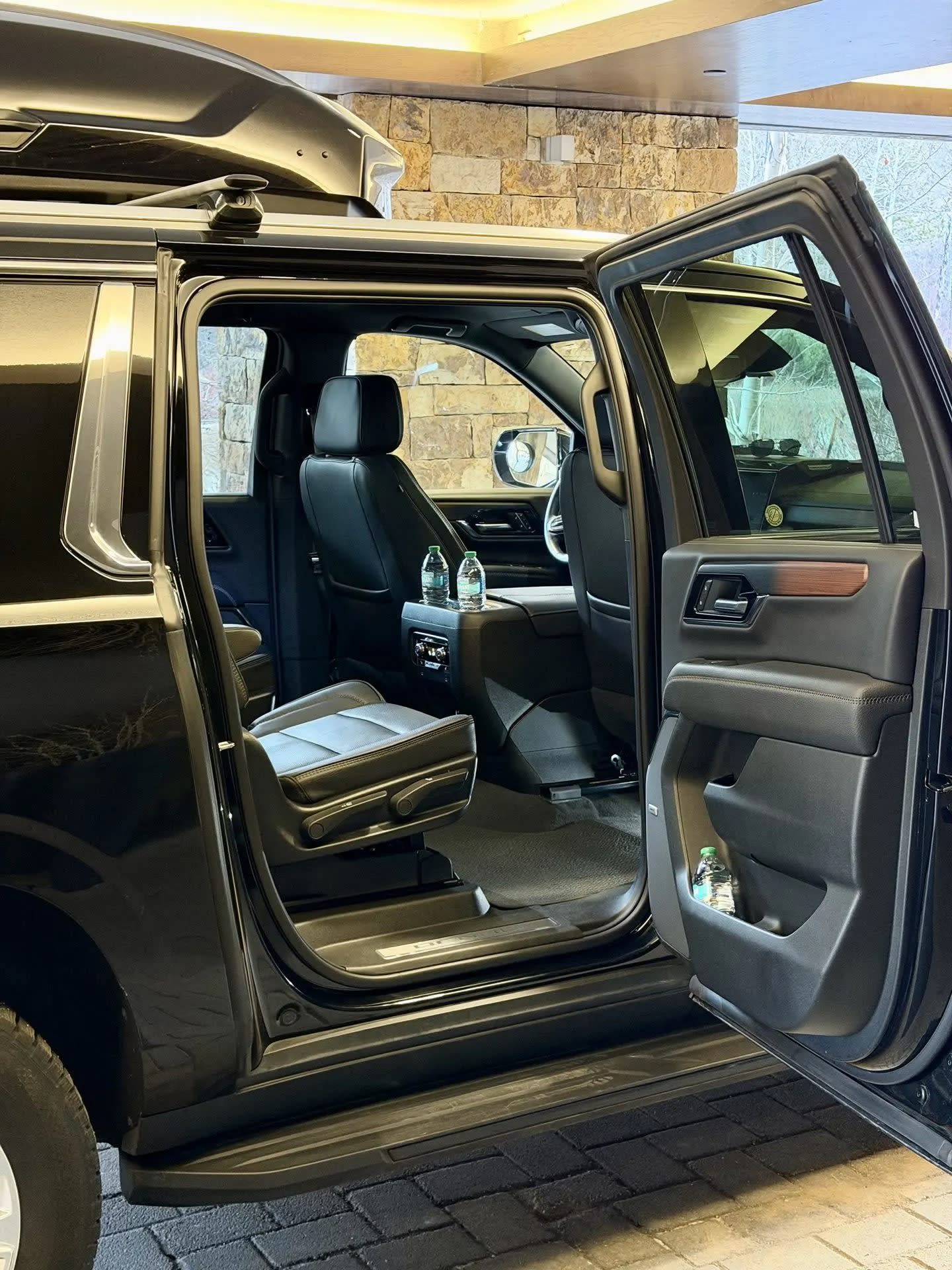 Open passenger door and leather seating inside a Blue Sky Limo GMC Yukon Denali