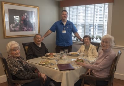 Image of a staff member and four residents at One MacDonough Place.