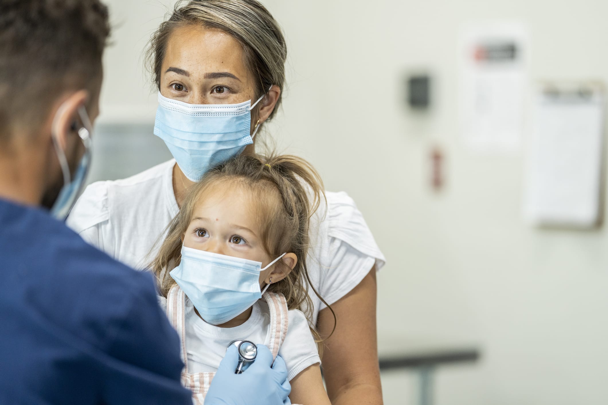 Mother and daughter discuss vaccines with their doctor.