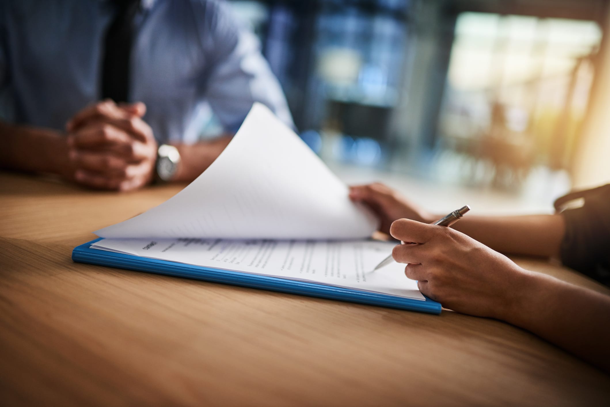 Two people signing and reviewing documents