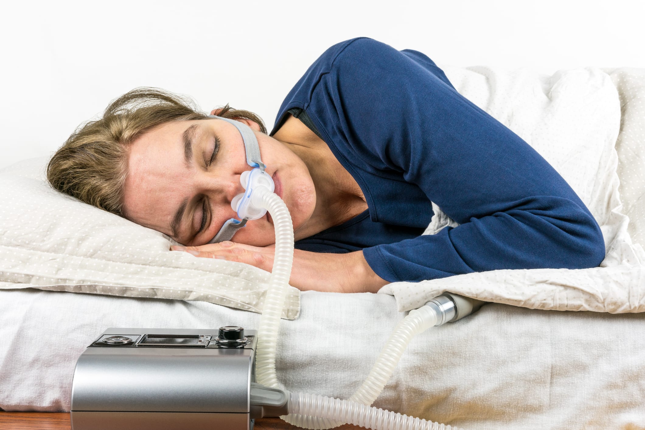 Woman sleeping with CPAP machine.