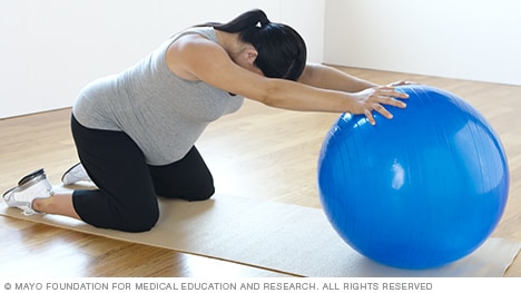 Estiramientos de brazos y abdominales sobre la pelota para la embarazada