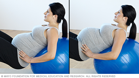 Estiramientos para el embarazo: mujeres embarazadas practican rotación posterior de la pelvis con una pelota de ejercicio