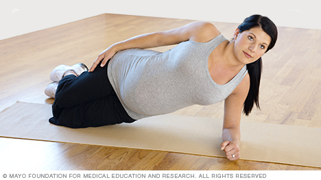 Pregnant person doing a modified side plank