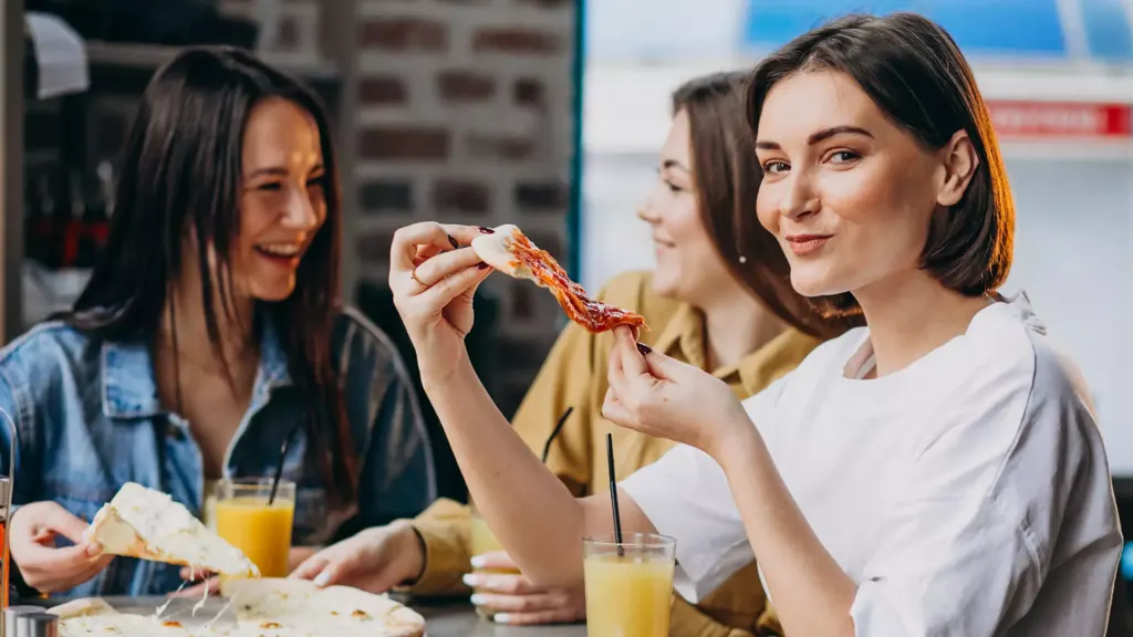 Happy friends eating pizza