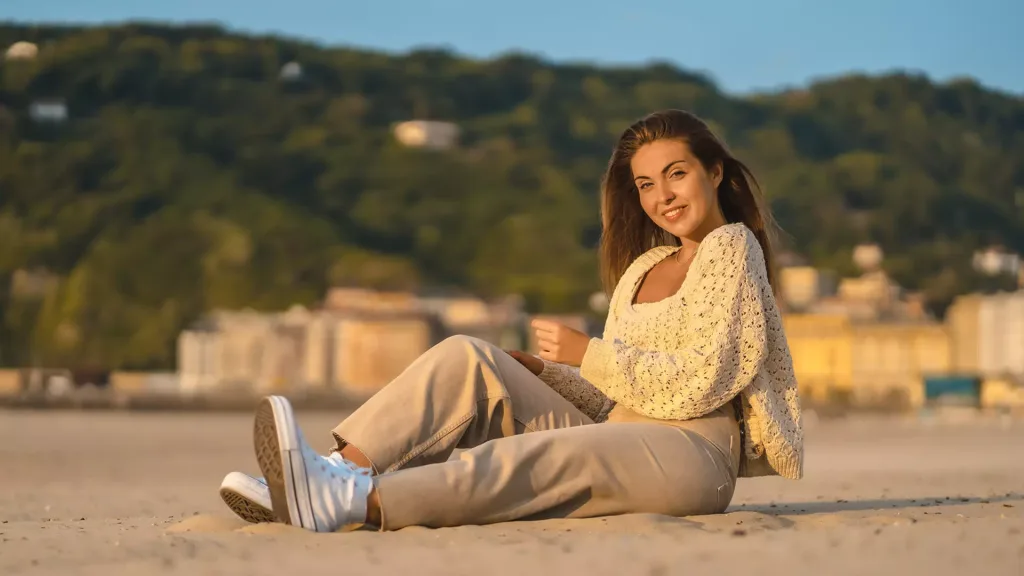 happy woman sitting in beach sand