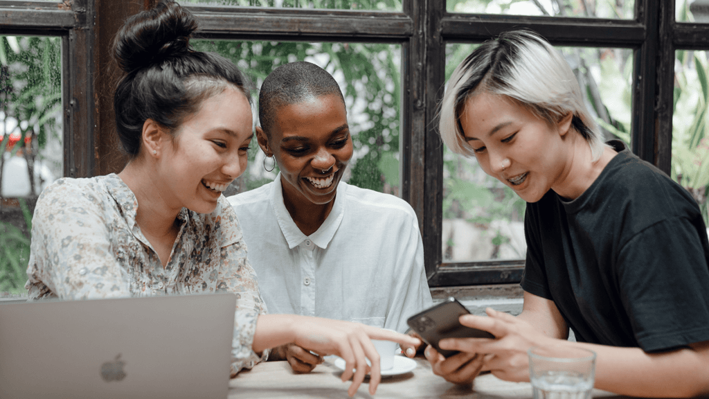3 women laughing at phone